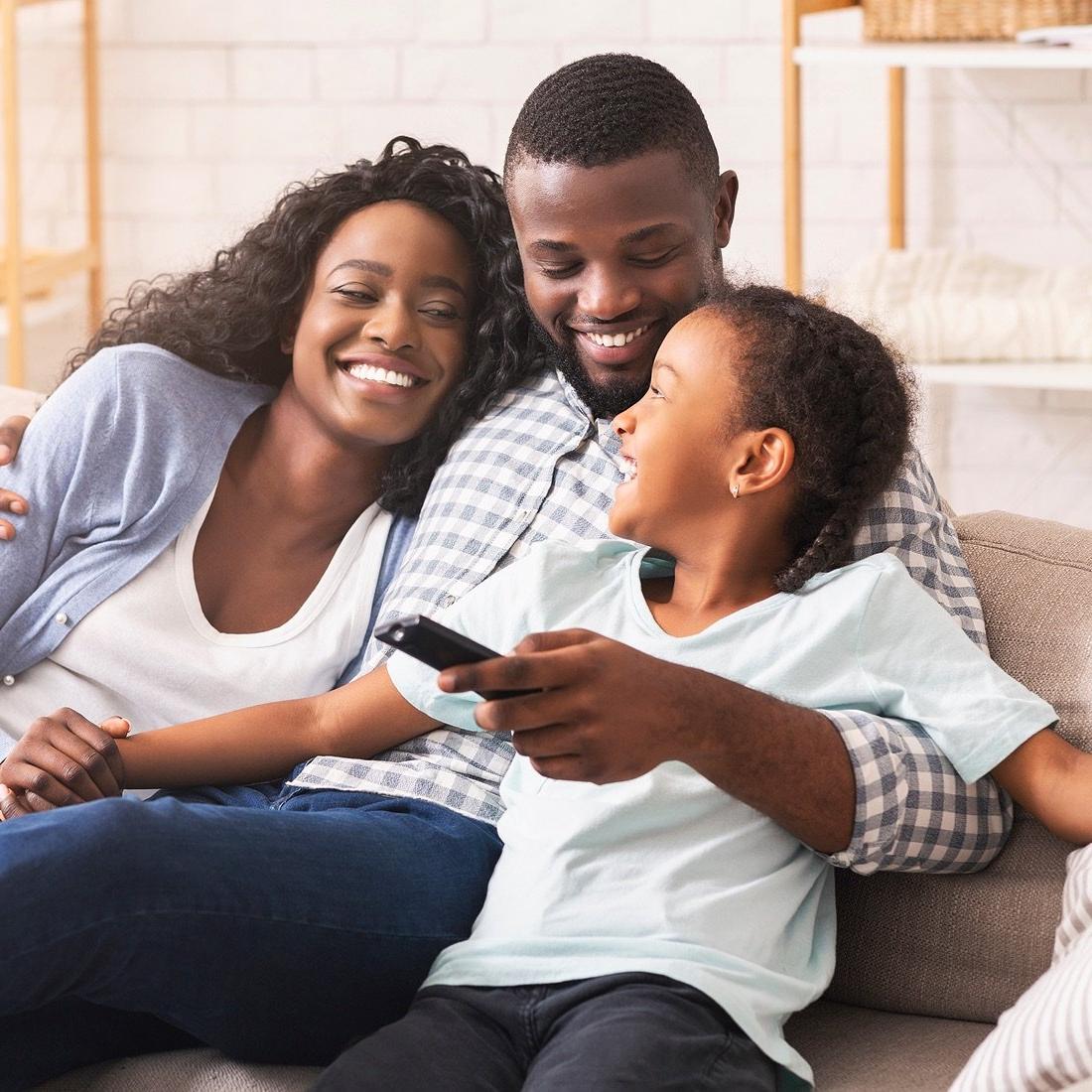 Family on the couch with tv remote.